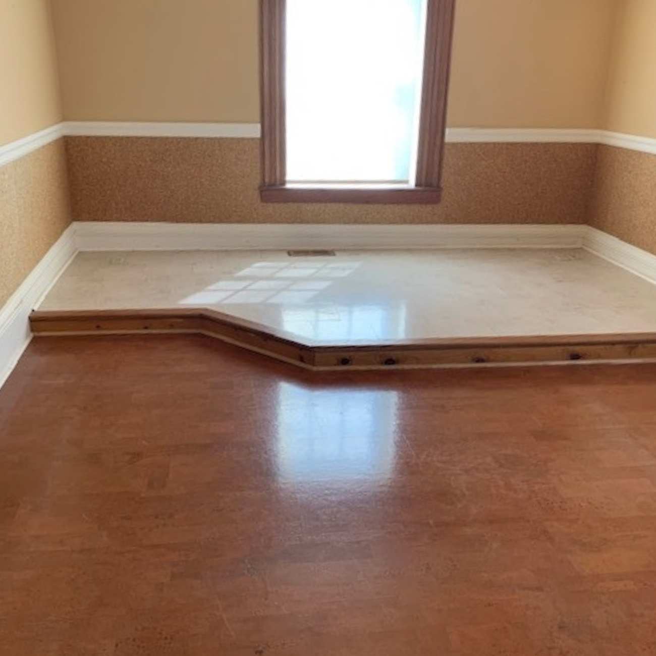 Room with harmony brown flooring with a white accent floor on a slightly raised platform.