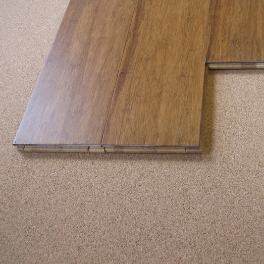 Cork underlayment under a dark brown wood floor plank