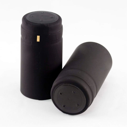 Two matte black closed cap PVC shrink cap with gold horizontal tear tab on a white background
