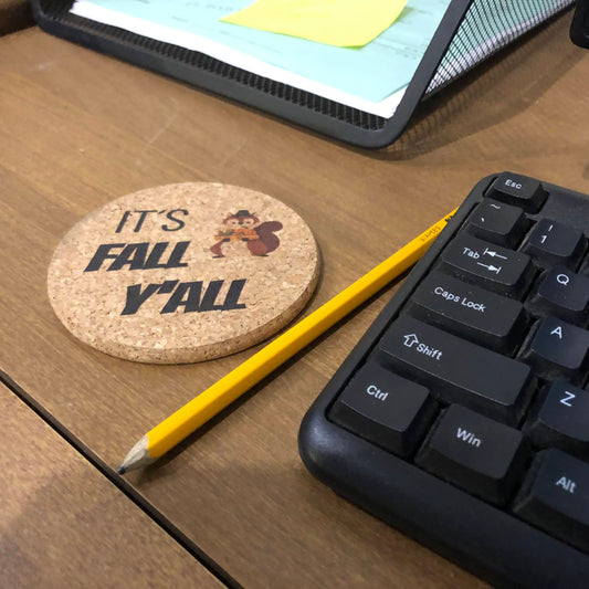 custom printed colour cork coaster on a desk next to a keyboard saying "It's fall y'all" with a squirrel in a top hat