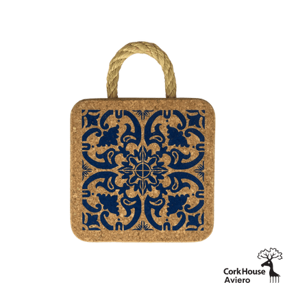 This cork hot pad features a rope handle for hanging and a cobalt blue traditional tile pattern. 