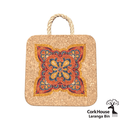 The 8in laranga hot pad features a swirling geometric pattern of marigold yellow, tangerine orange, cobalt blue and burgundy red with a twisted rope. 