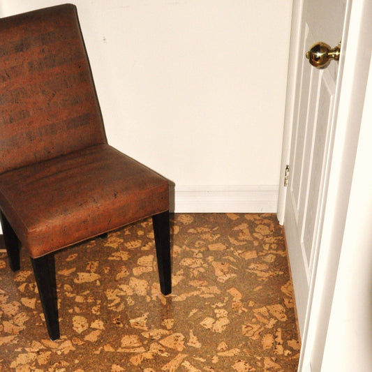 Brown chair on corkstone cork flooring featuring a brown and beige swirling pattern next to a white wall.