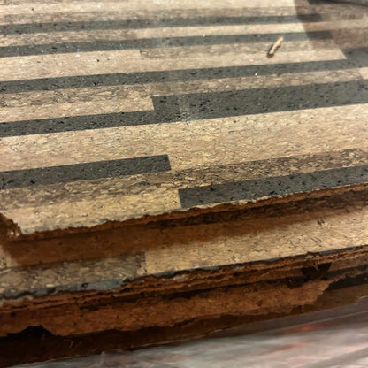 Side view of stacked Rio XL cork tiles showing rough, untrimmed edges.