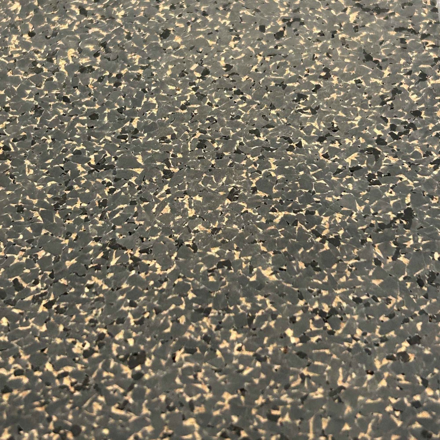 A close-up to show the pattern and colors of the Boulder rubber cork floor tile - speckles of dark grey, tan and black.