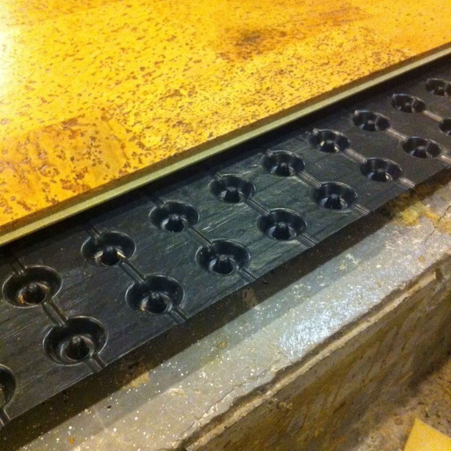 Closeup showing how Paton moisture barrier is installed over a concrete slab and under cork flooring