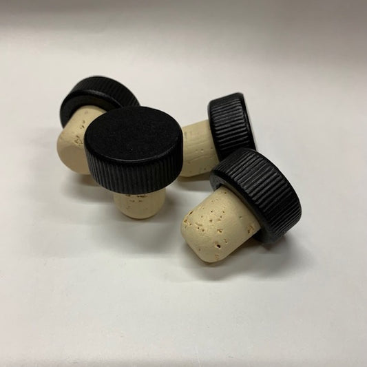 A pile of black wood top stopper with ribbed edges and a natural cork stem with rounded end. 