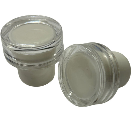 2 clear acrylic cap stoppers with white synthetic cork stems.