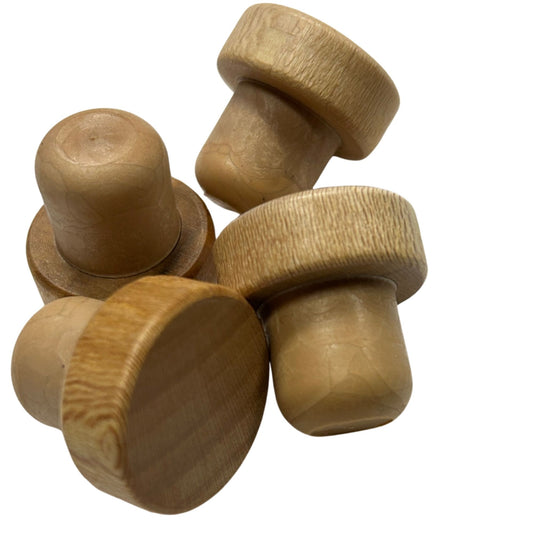 Four natural wood top bottle stoppers with visible grain patterns with tan synthetic stems, arranged on a plain white background.