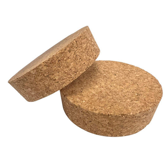 Closeup of two tapered cork stoppers showing agglomerated texture and conical shape, size SL54
