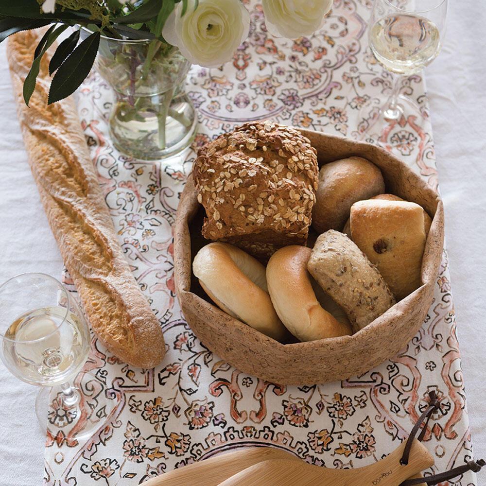 Foldable cork fabric bowl holding various breads